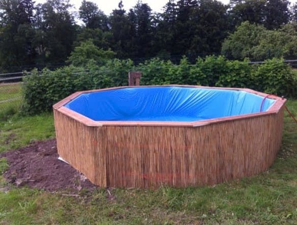 Avec seulement neuf palettes en bois, il fabrique sa piscine de jardin pour 50 euros