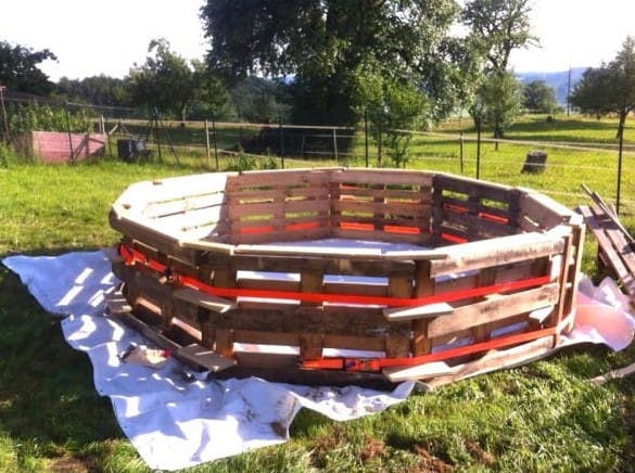 Avec seulement neuf palettes en bois, il fabrique sa piscine de jardin pour 50 euros
