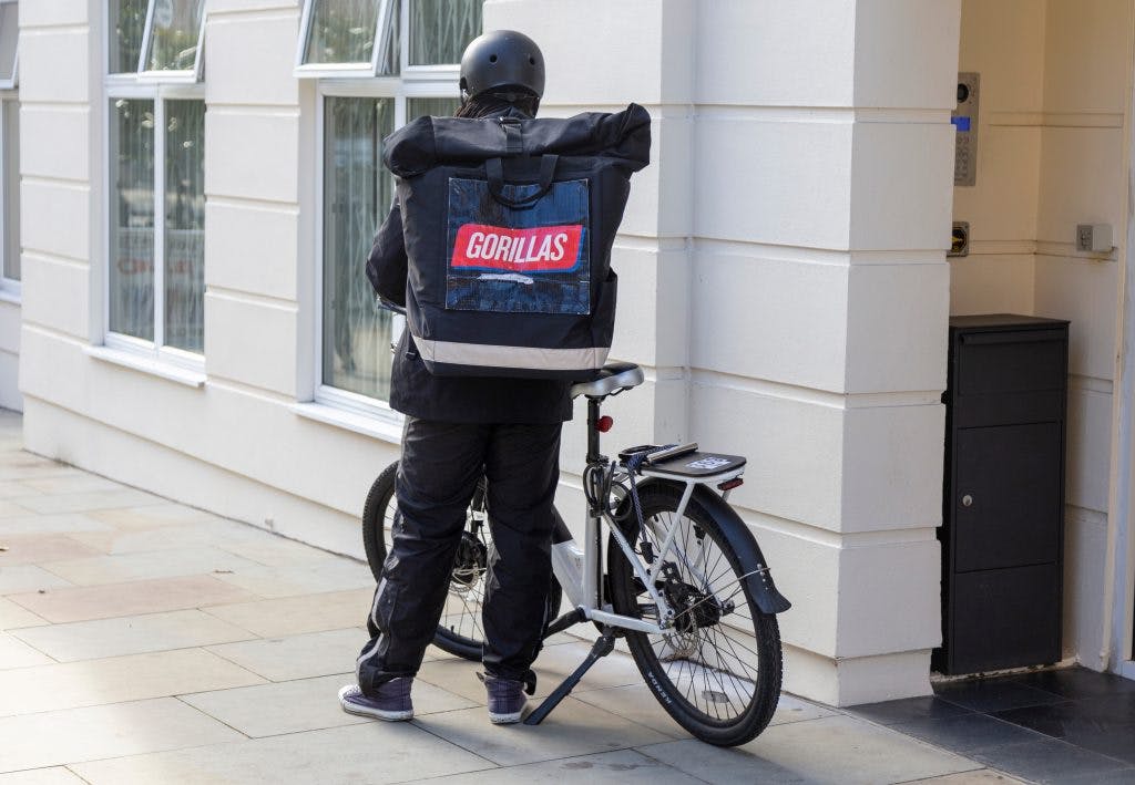 Un livreur Gorillas s'apprête à enfourcher son vélo pour livrer repas et courses en instantané. Photo : Shutterstock.