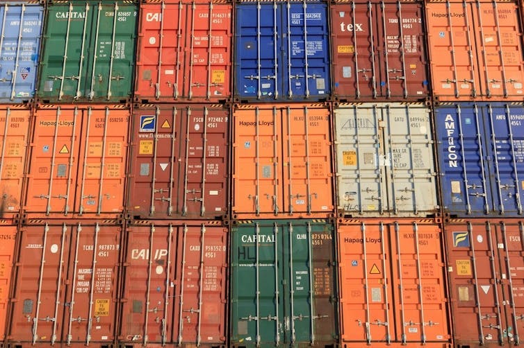 Alignement de conteneurs colorés empilés sur un quai ou dans une zone industrielle