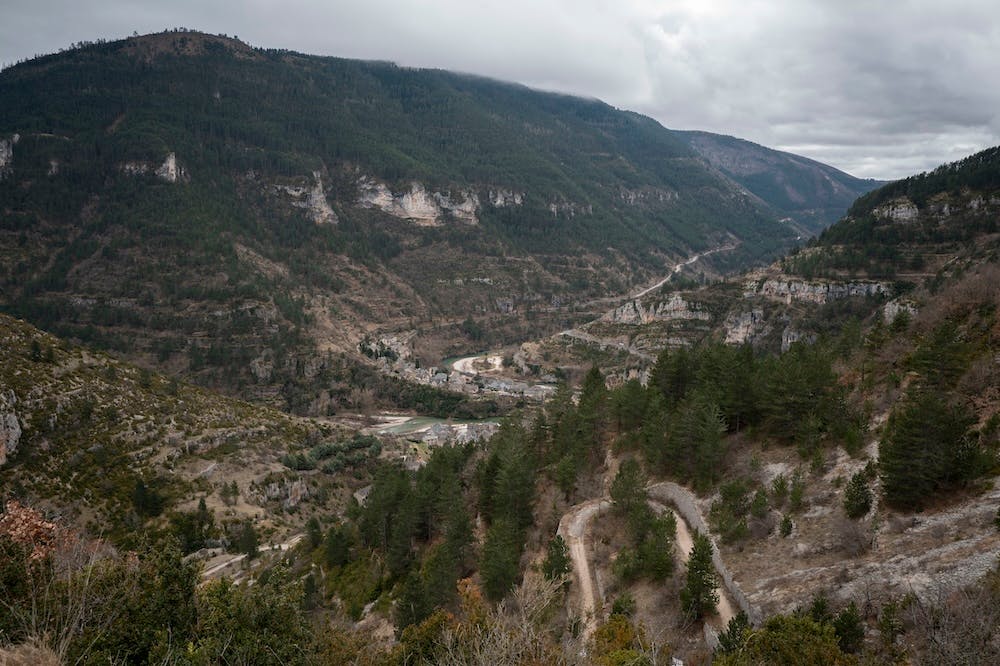 Vallée encaissée entourée de montagnes boisées sous un ciel nuage