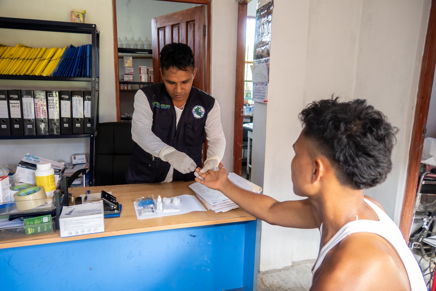Un professionnel de santé effectue un test sanguin rapide sur un patient dans un bureau.