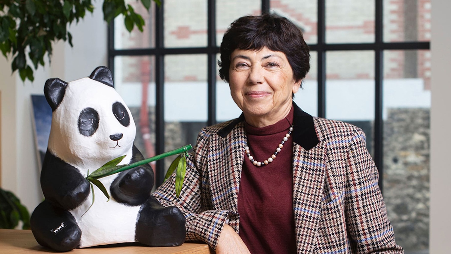 Monique Barbut souriante posant à côté d&#039;une peluche de panda tenant une branche de bambou