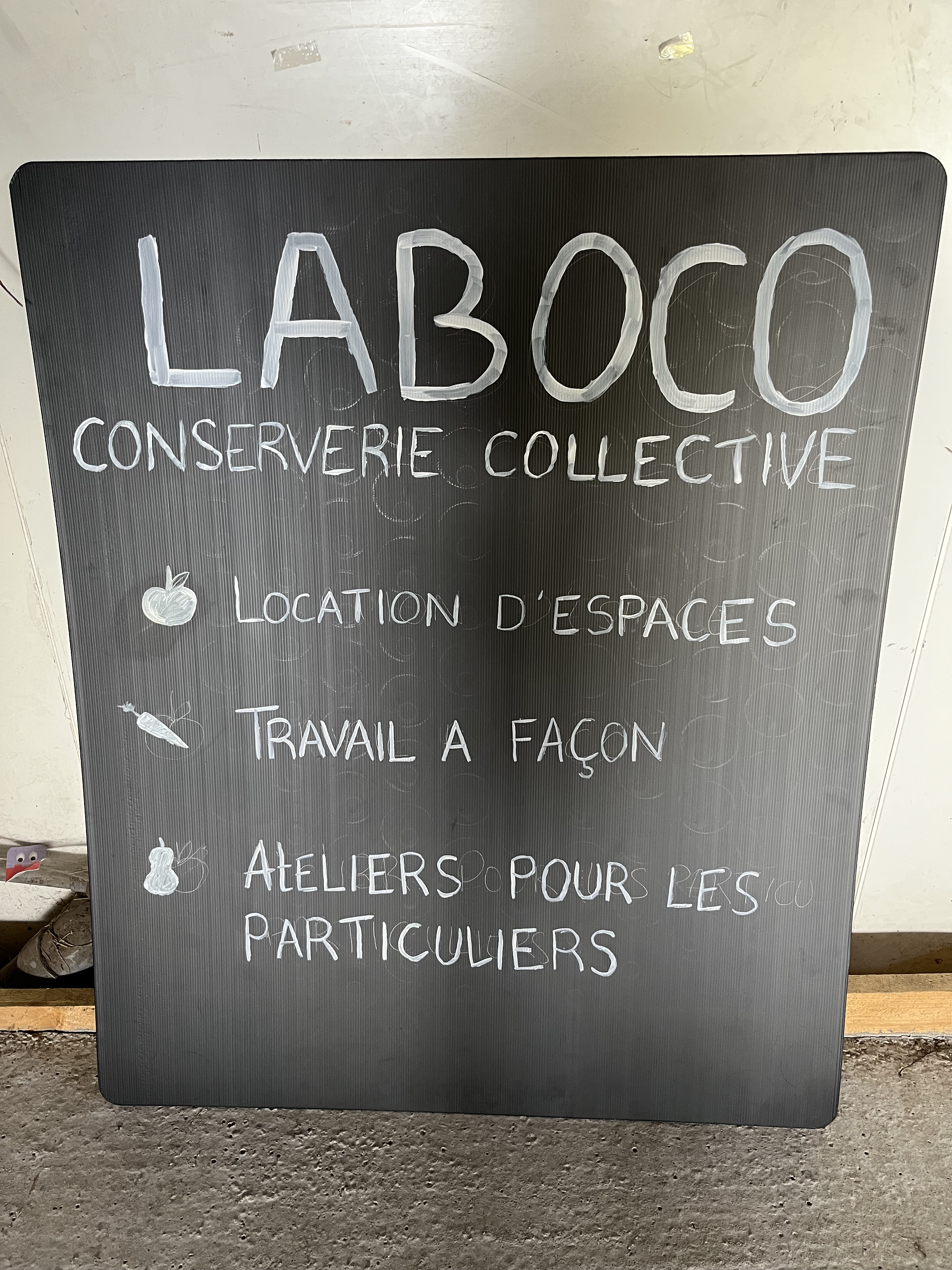 Tableau noir présentant les services de la conserverie collective Laboco : location, travail, ateliers.
