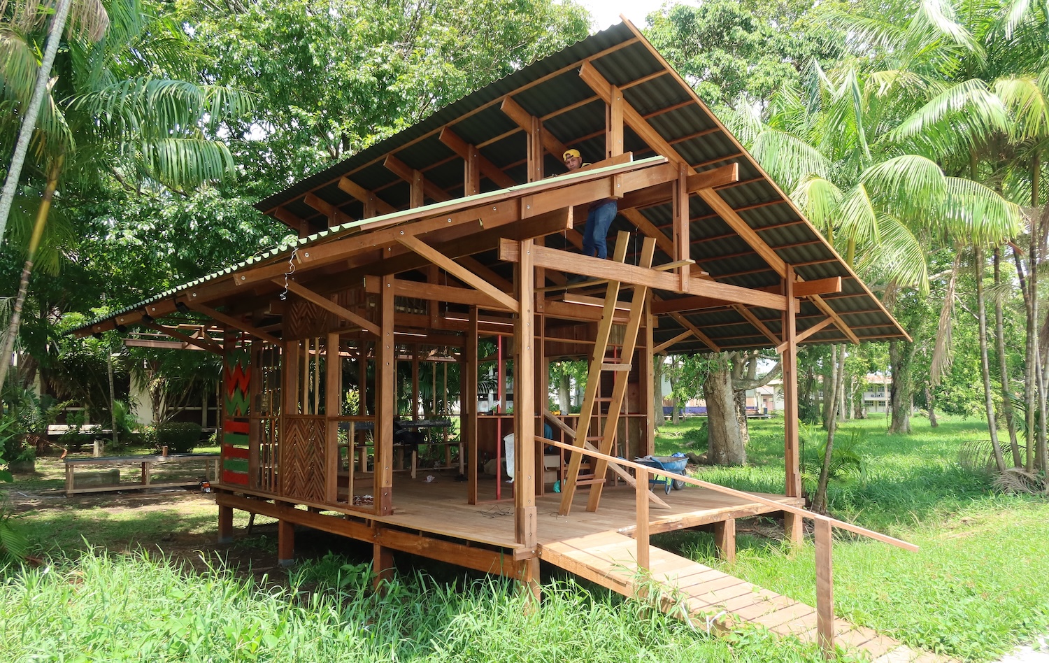Construction d'une maison en bois sur pilotis au milieu d'une végétation tropicale