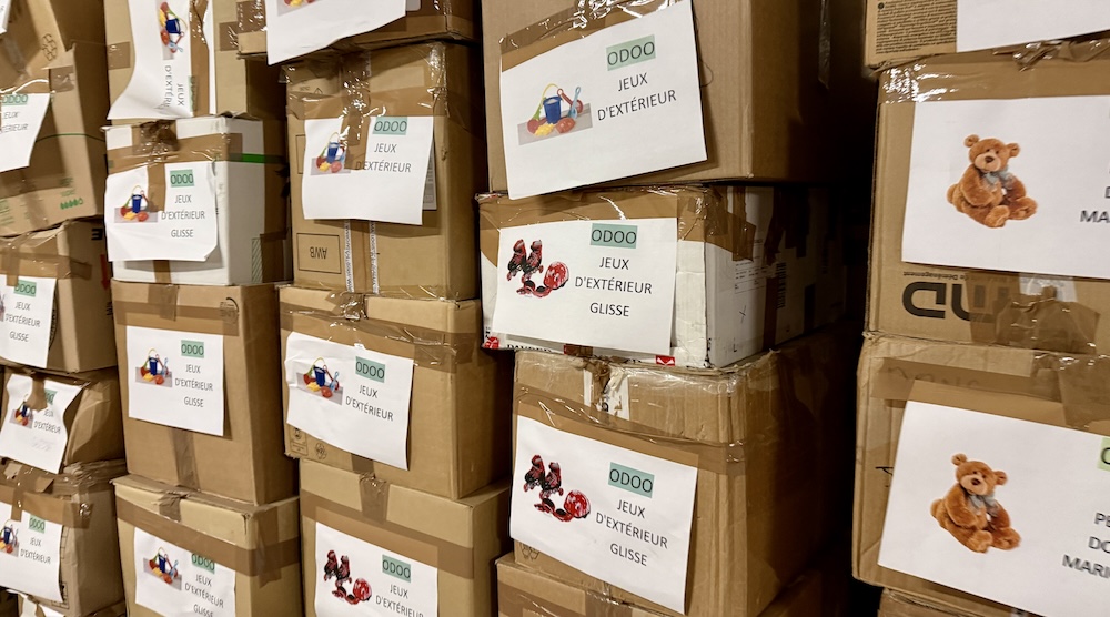 Cartons empilés étiquetés avec des images de jouets pour une collecte ou distribution.