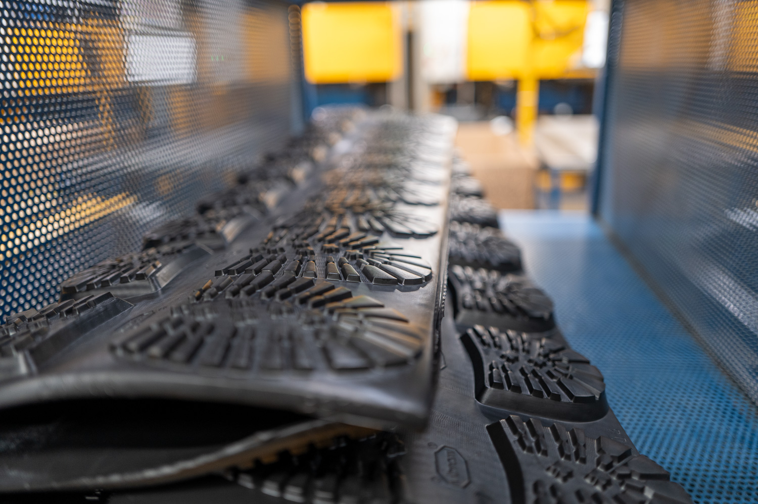 Semelles de chaussures en caoutchouc alignées sur une chaîne de production en usine