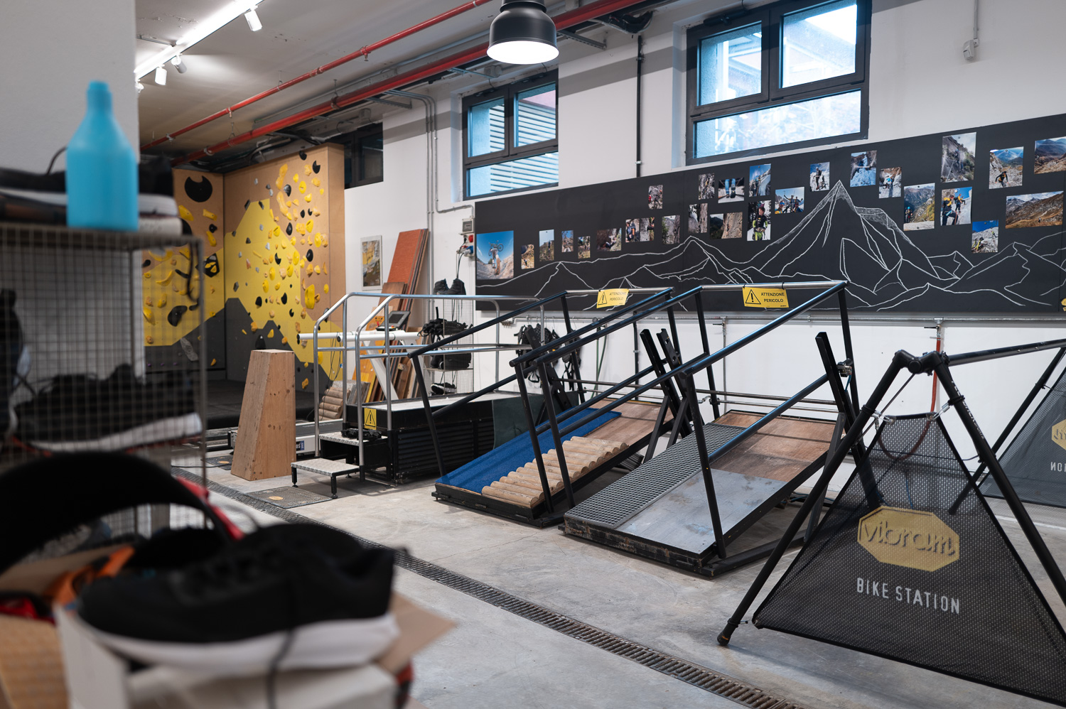 Salle d’essai de chaussures avec rampes inclinées et mur d’escalade en fond.
