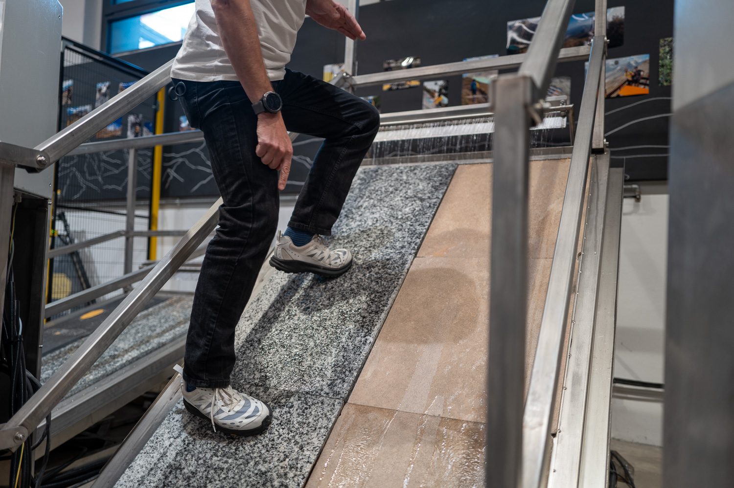 Homme testant l'adhérence de différents revêtements sur une rampe inclinée en laboratoire.