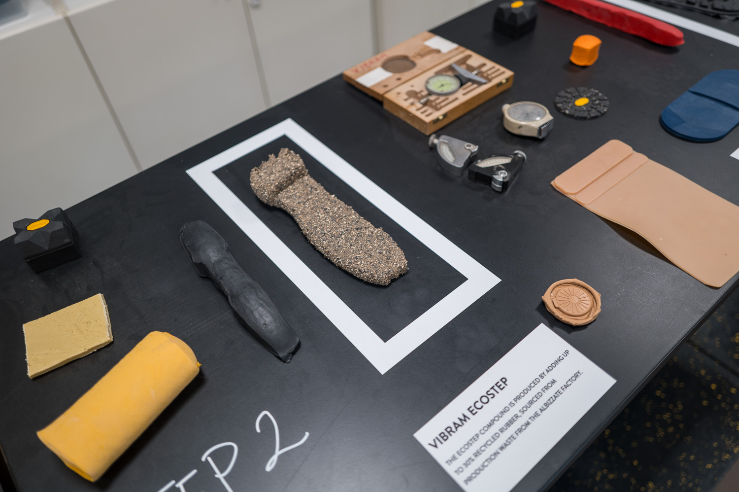 Objets écoconçus exposés sur une table noire, incluant matériaux recyclés et prototypes durables.