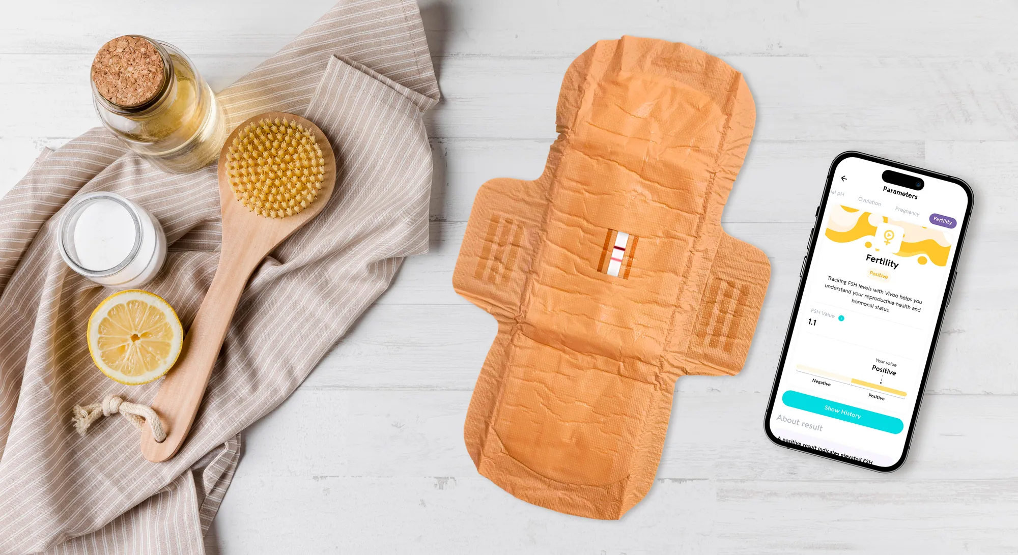 Serviette hygiénique marron, produits de soin naturels et téléphone affichant une application de suivi menstruel