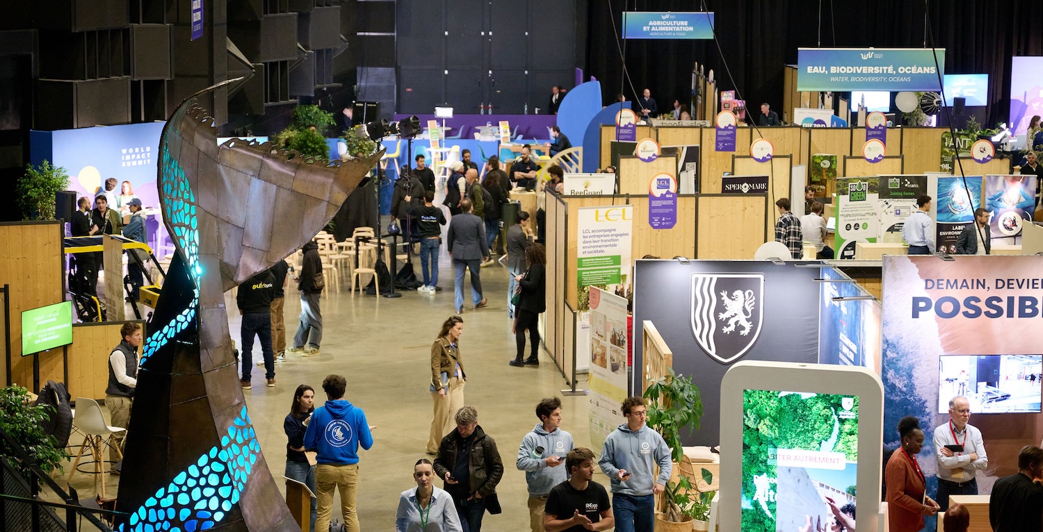 Salon professionnel avec de nombreux stands, visiteurs circulant dans une grande salle d’exposition animée.