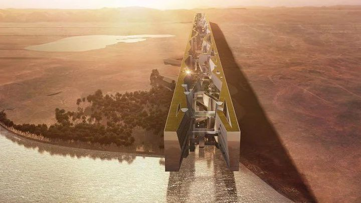 Projet urbain futuriste en forme de mur miroir traversant désert et plan d’eau au coucher du soleil