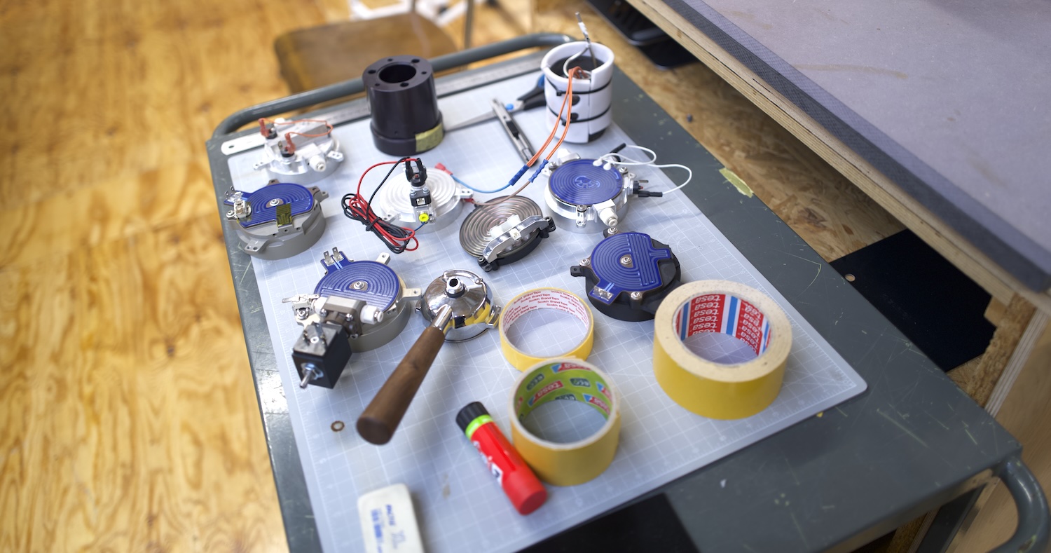 Équipement technique sur une table avec ruban adhésif et divers outils sur un plateau.