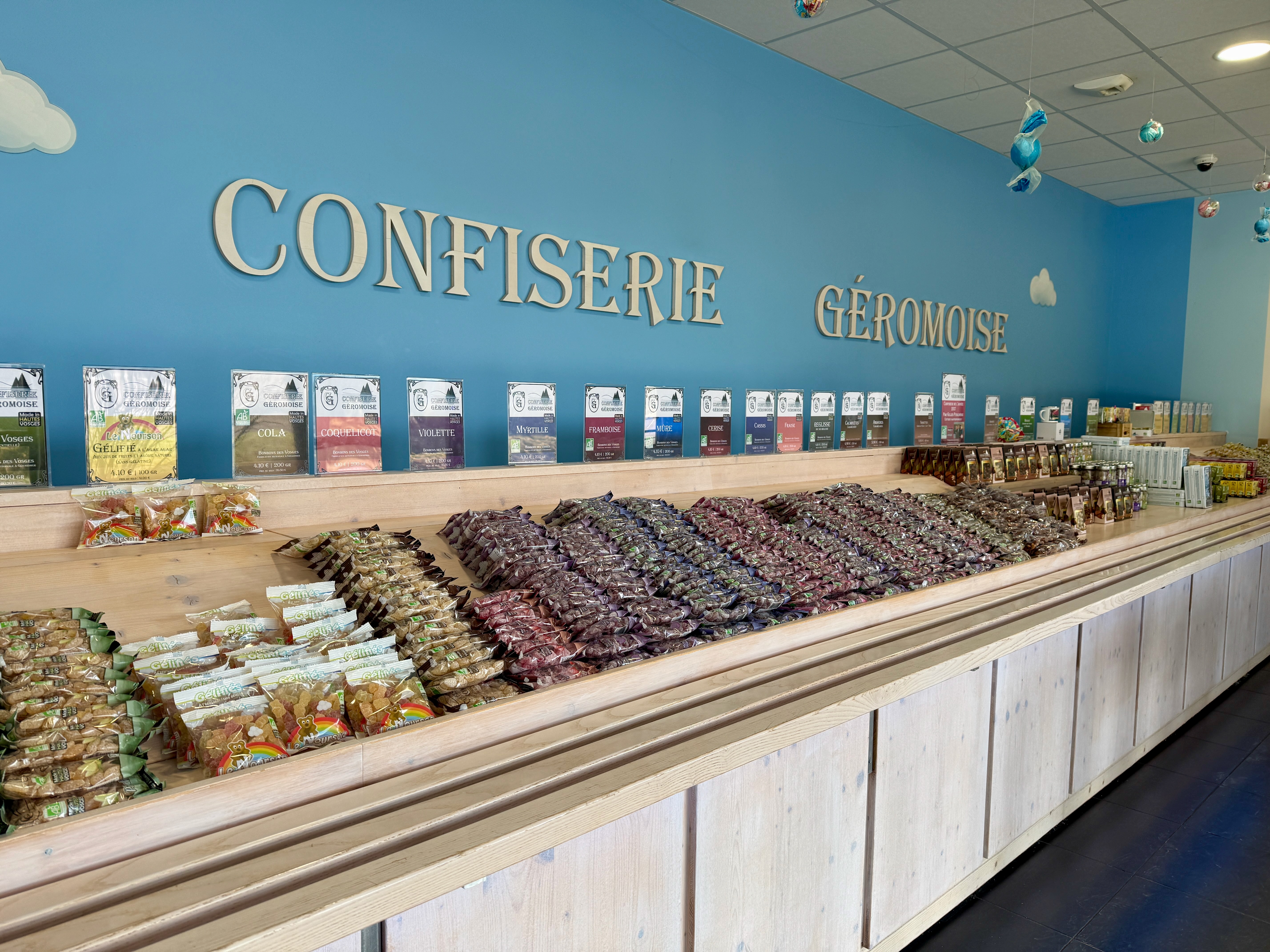 Confiserie Gérômoise avec étalage de bonbons et chocolats en sachets colorés.