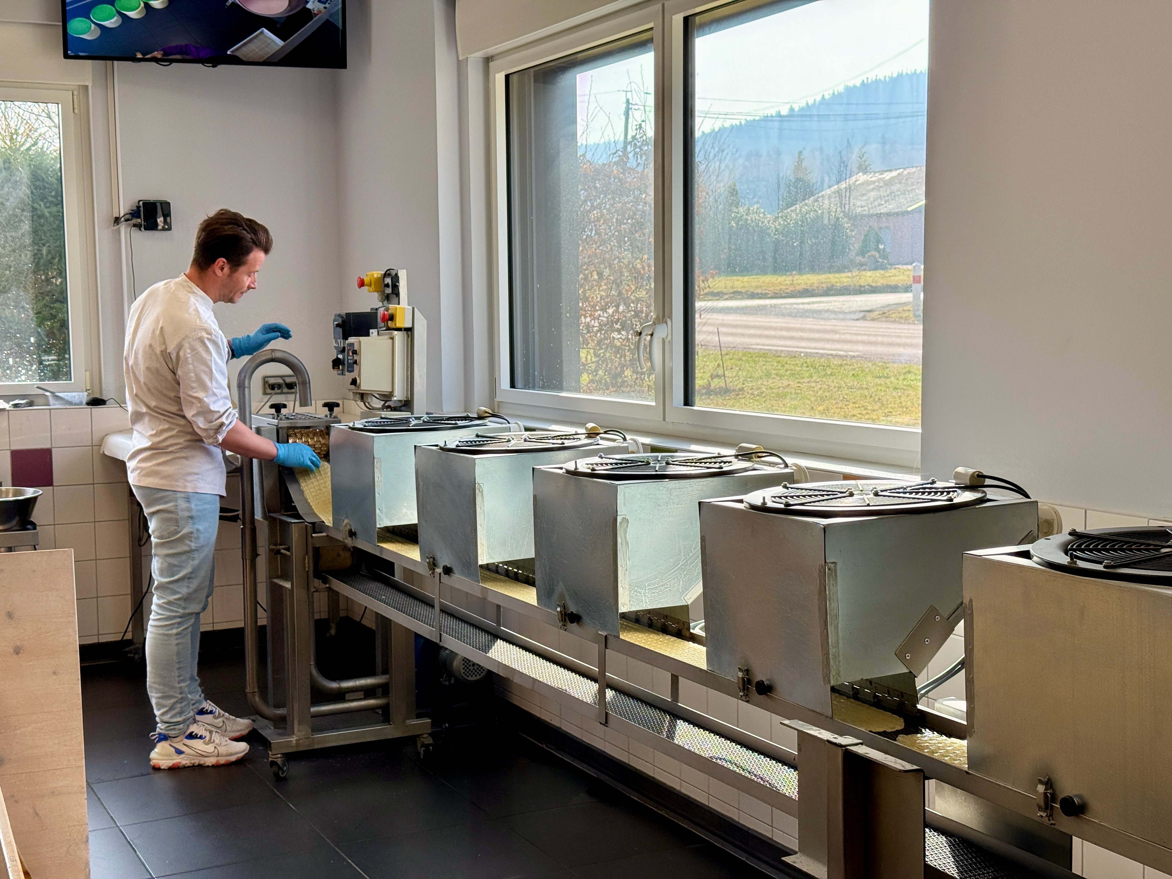 Un homme travaille dans un laboratoire avec plusieurs machines près d'une fenêtre.