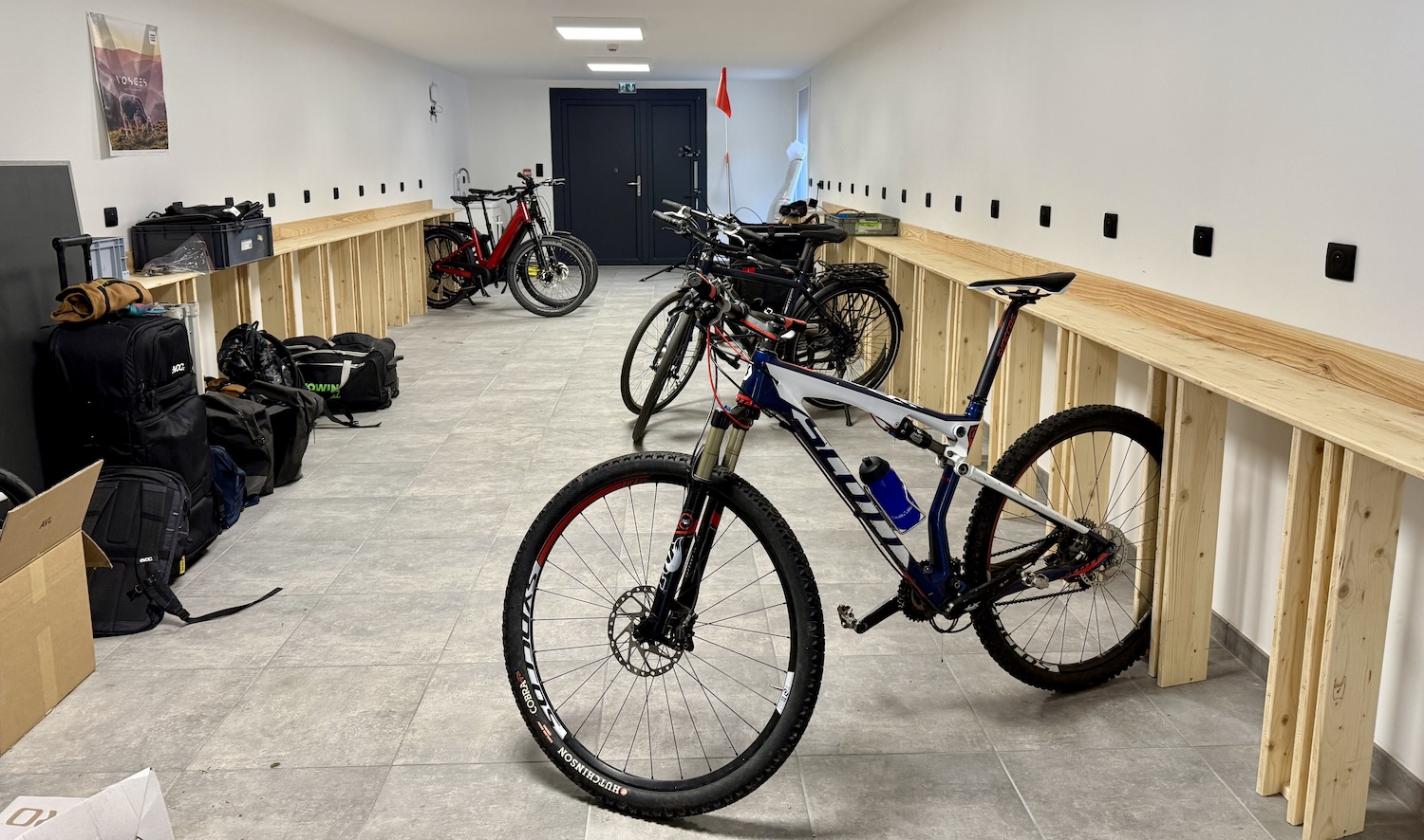 Salle avec plusieurs vélos alignés et rangements en bois le long des murs.
