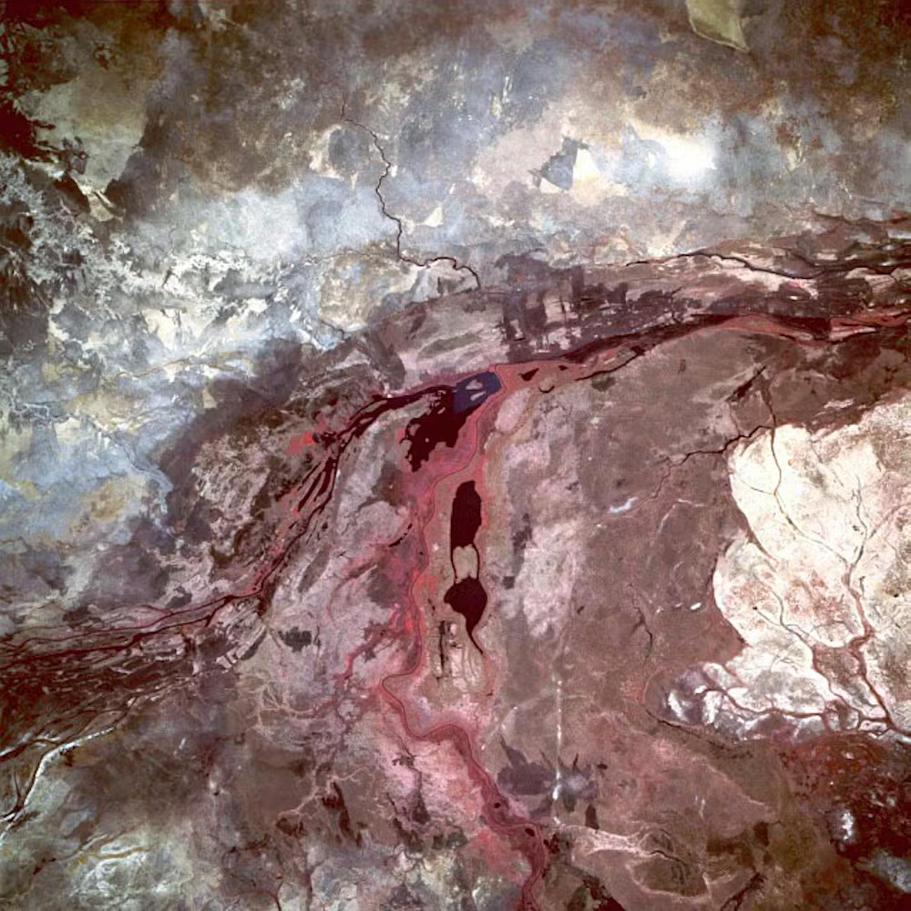 Roche volcanique avec coulée de lave séchée et variations de couleurs rouge et brun.