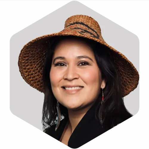 Femme souriante portant un chapeau en osier, fond gris.