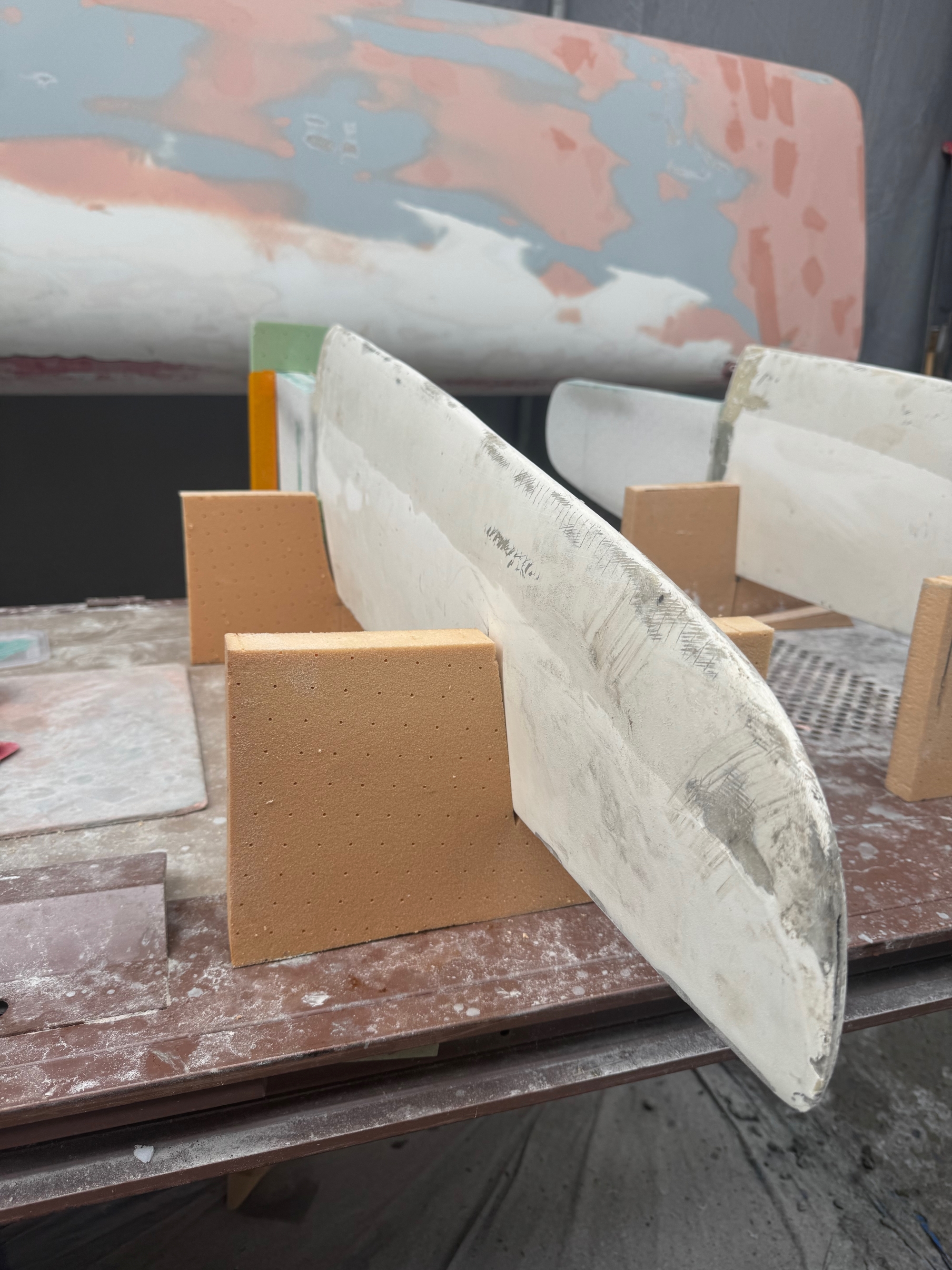 Gouvernail amovible en cours d'installation, posé sur des supports en bois dans un atelier.