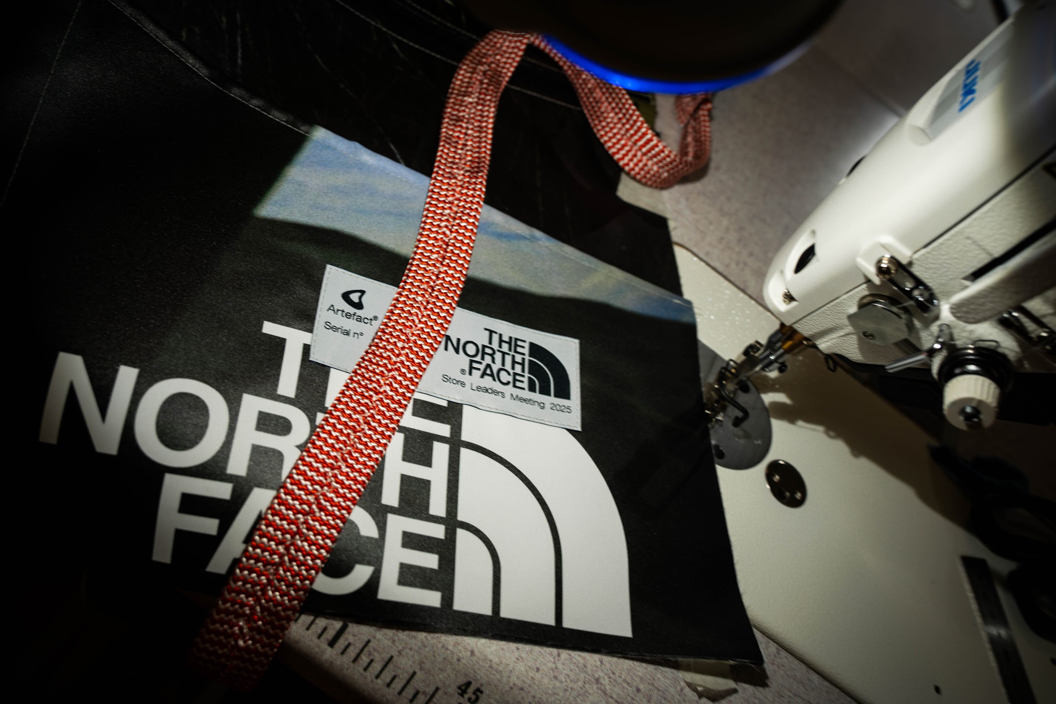 Sac The North Face sur table près d'une machine à coudre.