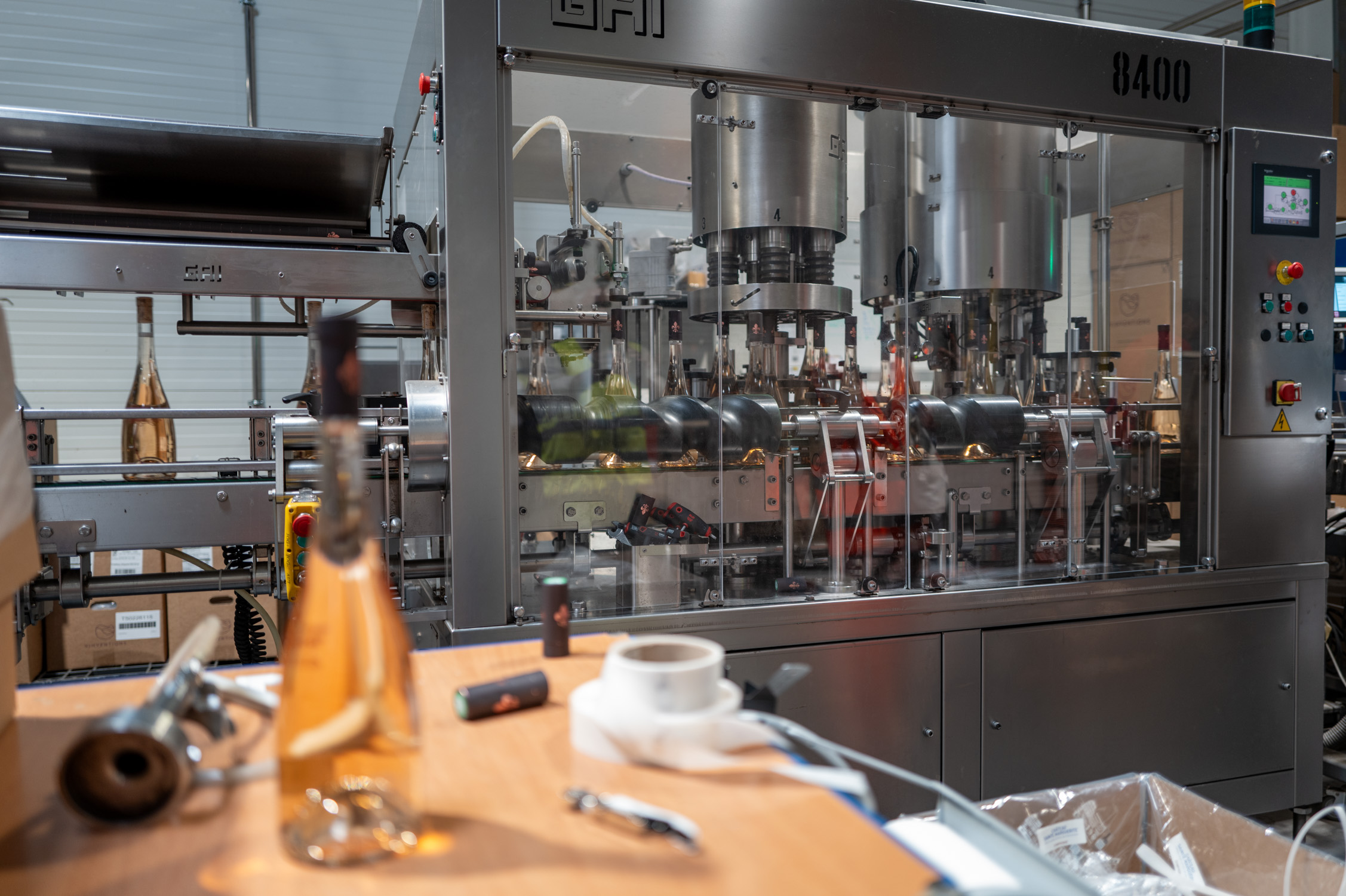 Machine d'embouteillage automatique dans une usine, bouteilles et matériel de production en vue.