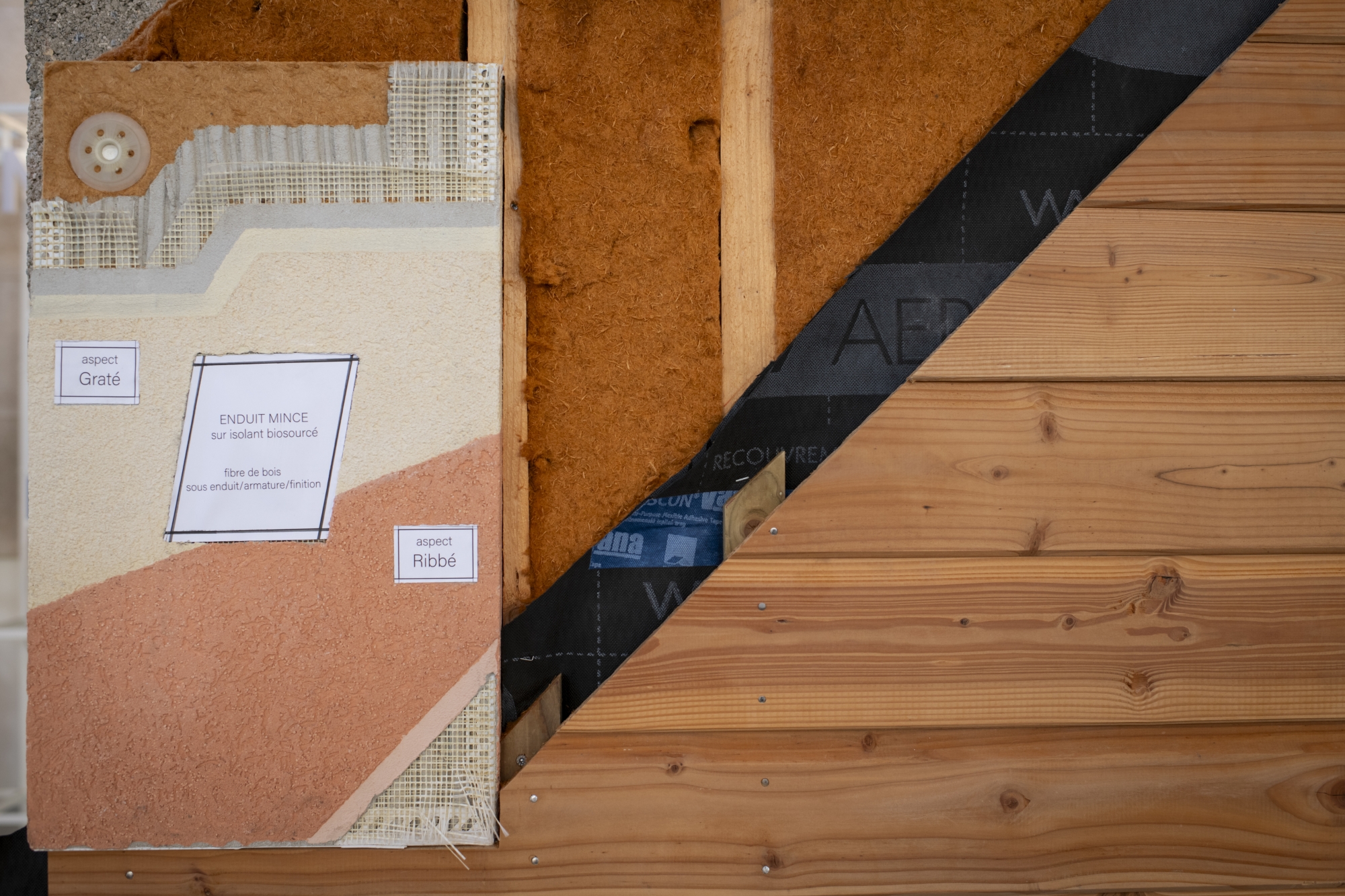 Coupe transversale d'un mur avec isolants, bois et autres matériaux de construction.