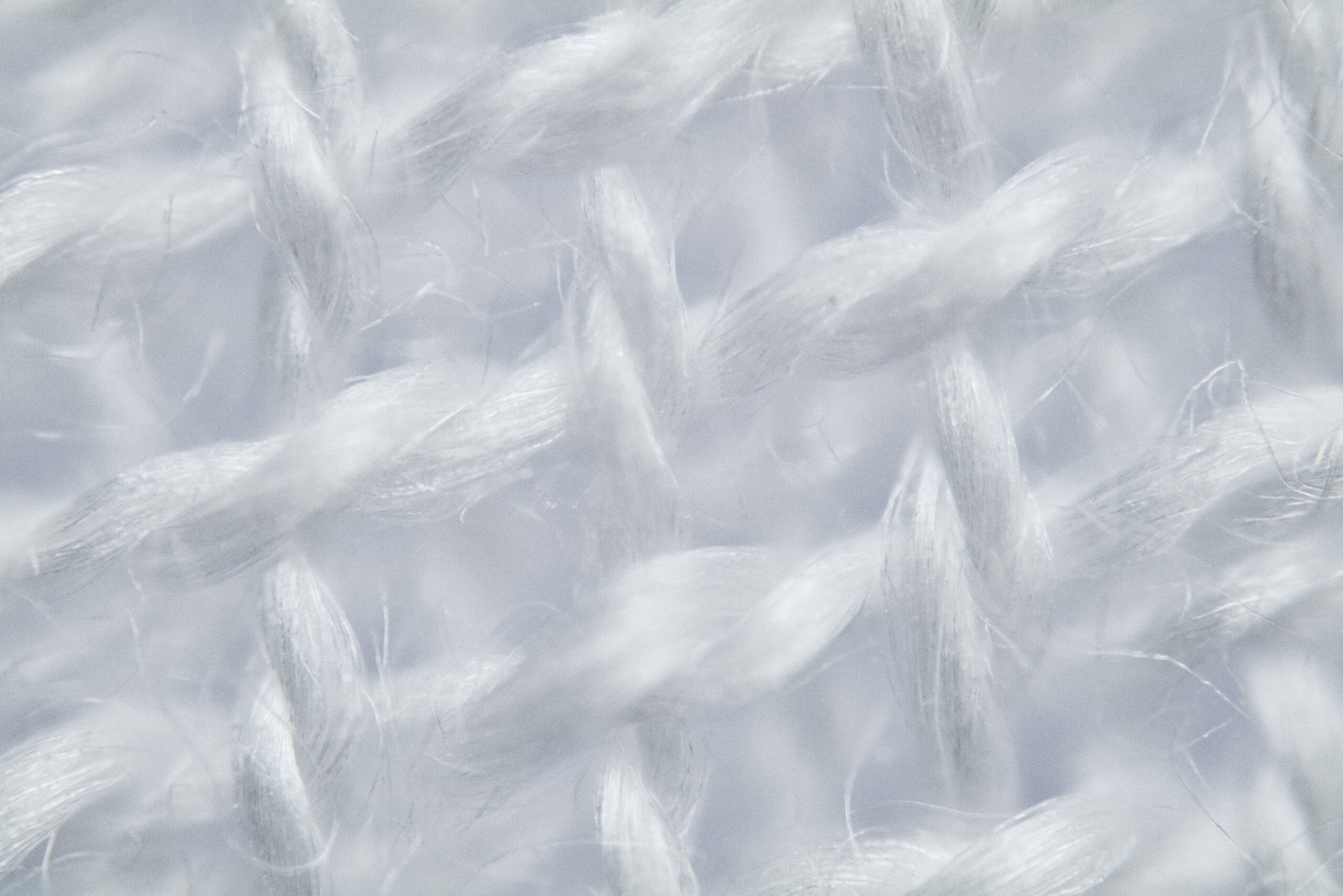 Gros plan sur une texture de tissu blanc tissé avec des fils entrecroisés.