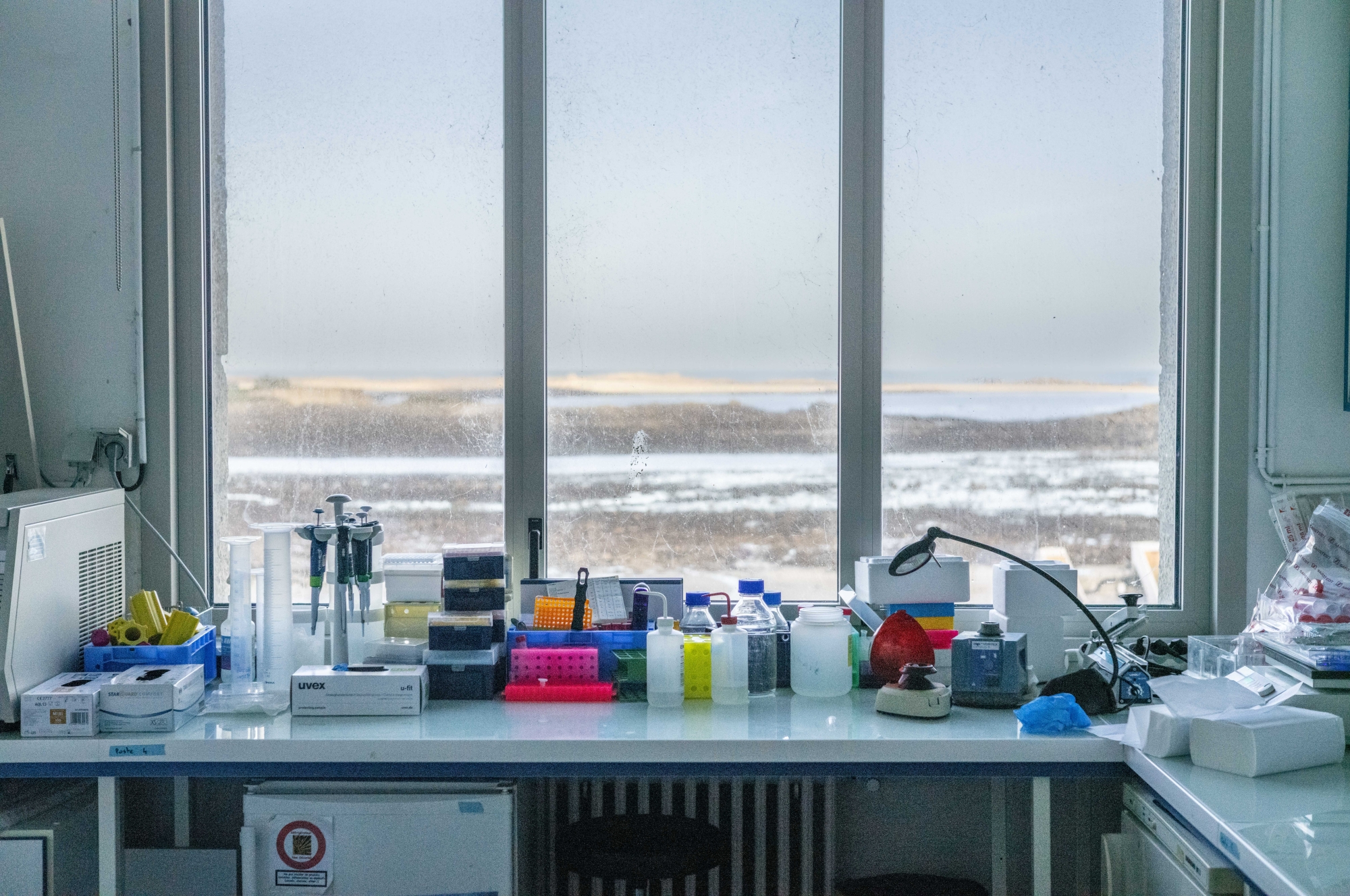 Laboratoire moderne avec équipement scientifique et vue sur un paysage enneigé par la fenêtre.