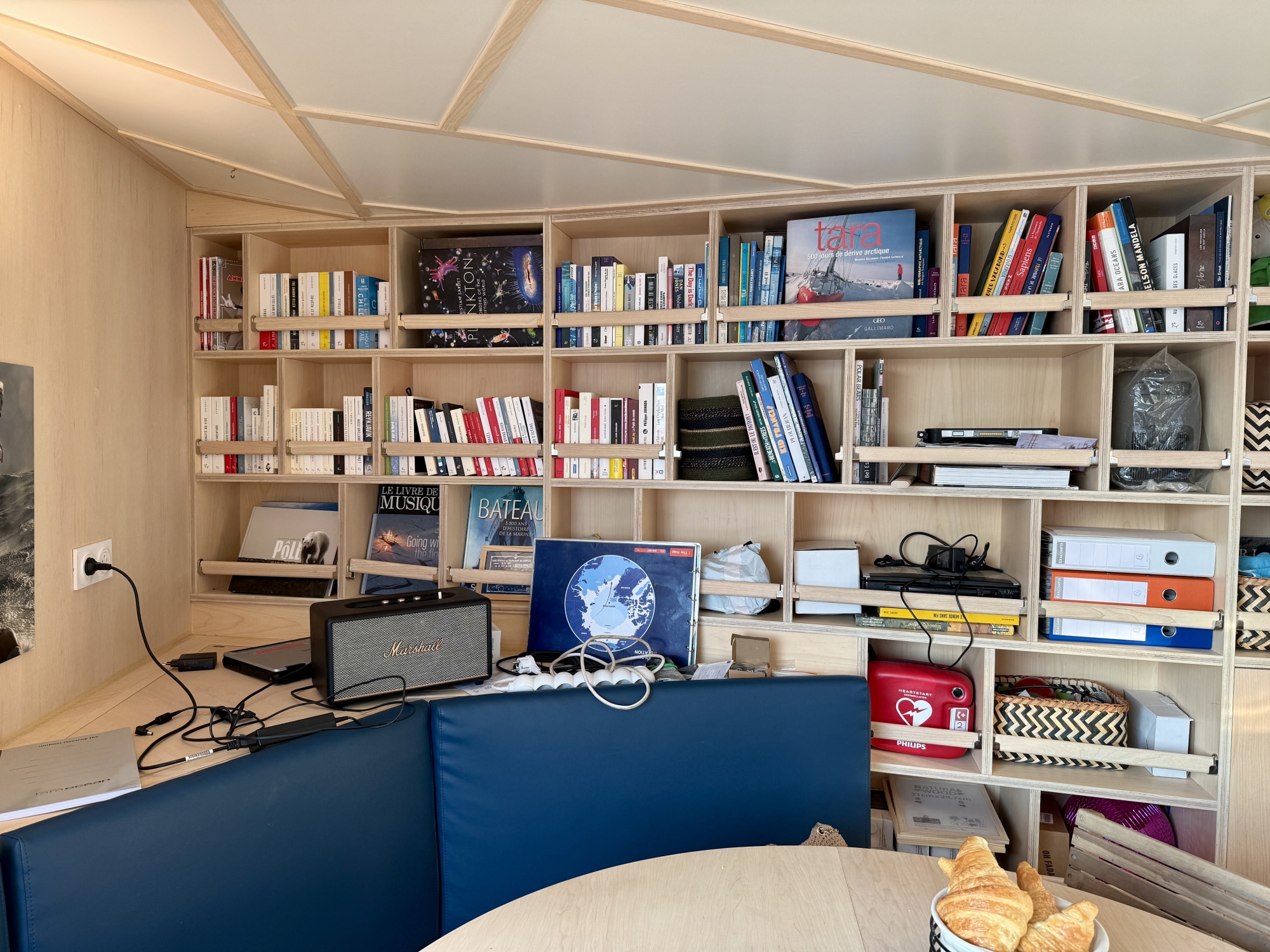Bureau moderne avec étagères remplies de livres et ordinateurs portables sur le bureau.