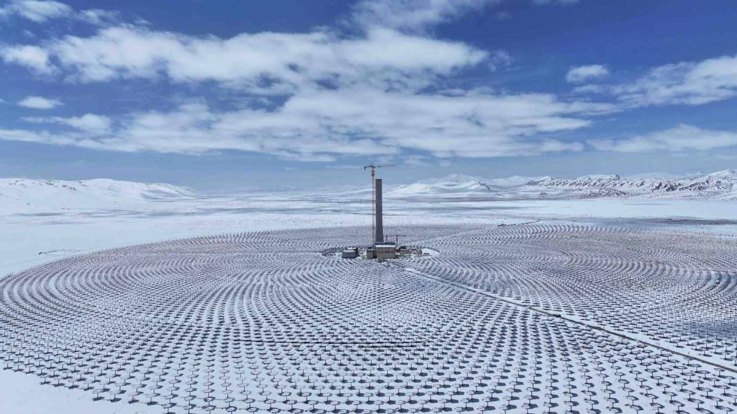 Centrale solaire dans un paysage enneigé avec des miroirs disposés en cercle autour d'une tour