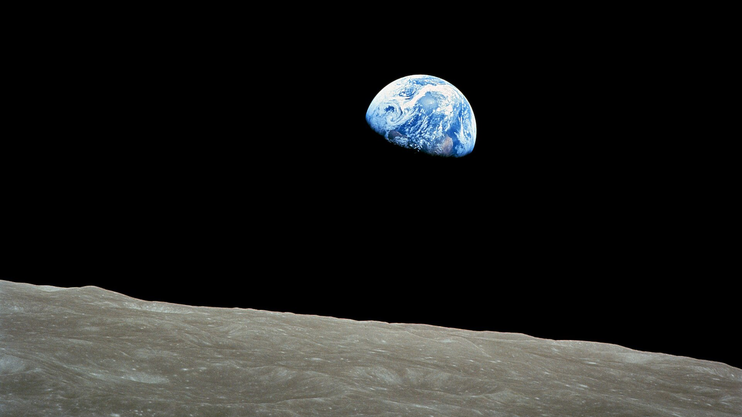 Vue de la Terre depuis la Lune avec un horizon lunaire en premier plan.