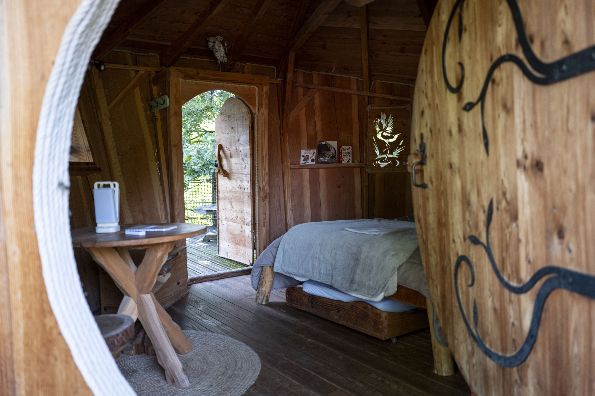 Intérieur rustique en bois avec lit et petite table, ambiance chaleureuse et naturelle.