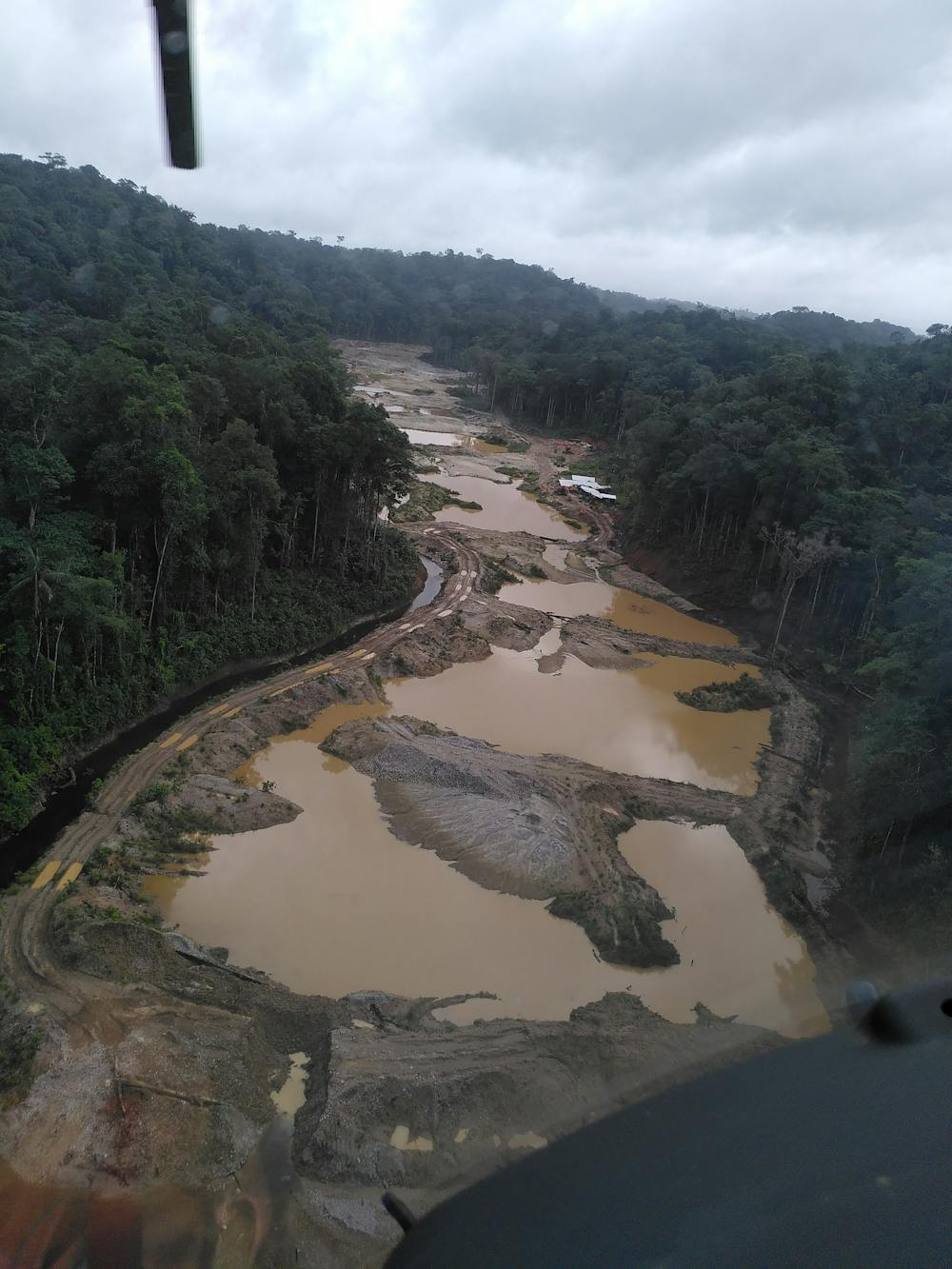 Vue aérienne d'une zone de déforestation et d'exploitation minière illégale dans la forêt tropicale.
