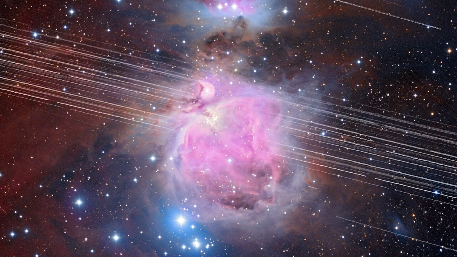 Nébuleuse d'Orion avec traînées de satellites traversant l'image dans un ciel étoilé.