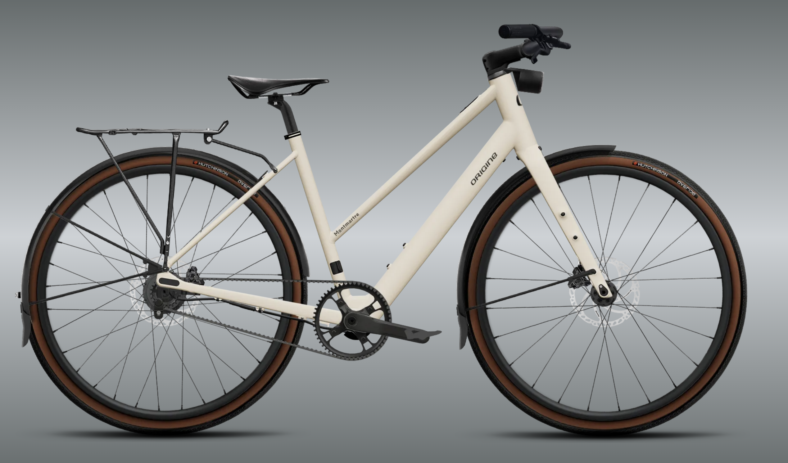 Vélo de ville moderne avec cadre bas, pneus marron et porte-bagages arrière.